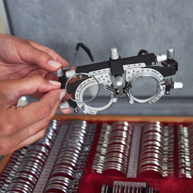 Doctor equipment. Female hands holding the optical device for eye testing.